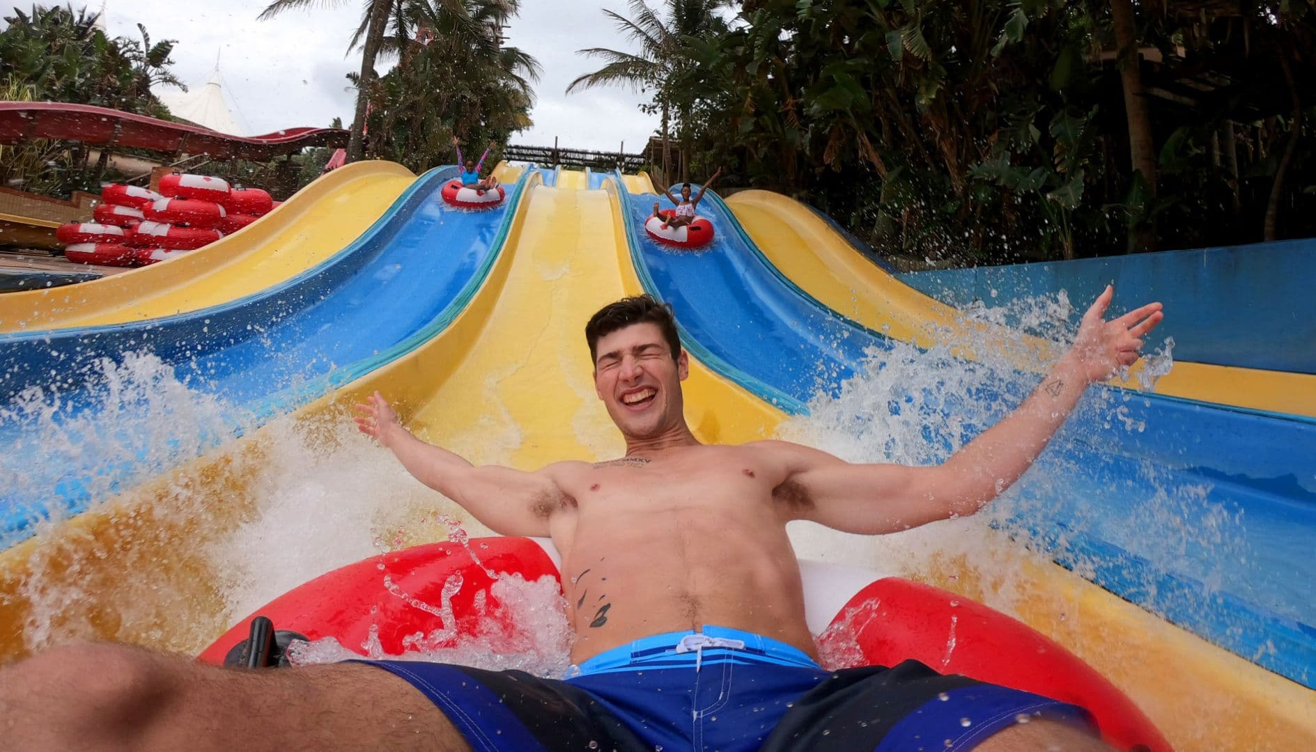 A picture of a man sliding down a water slide on an inflatable tube.